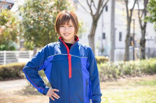 A woman wearing blue work clothes and putting her hand on her waist, female, work clothes, a smile, JPG