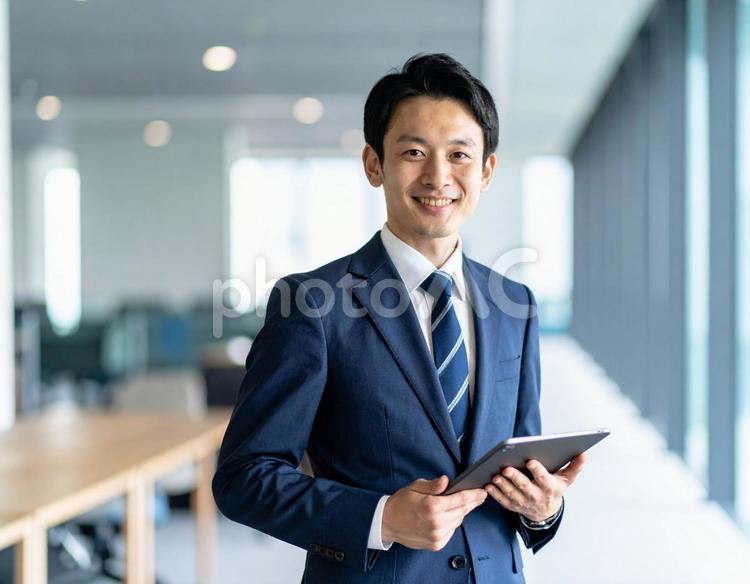 タブレットを手にしているサラリーマン 男性,タブレット,サラリーマンの写真素材