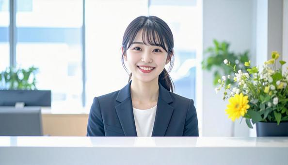 笑顔で対応する女性の受付嬢 笑顔で対応する女性の受付嬢の写真