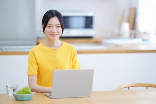 カメラ目線で笑うパソコン作業をしている女性 女性,ノートパソコン,座るの写真素材