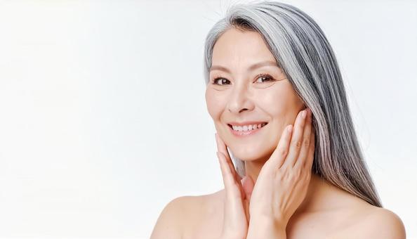 笑顔で肌のスキンケアをするシニア女性 笑顔で肌のスキンケアをするシニア女性の写真