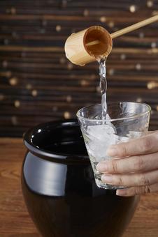 甕に入った焼酎をグラスに注ぐ 甕に入った焼酎をグラスに注ぐ 焼酎,柄杓,甕の写真素材