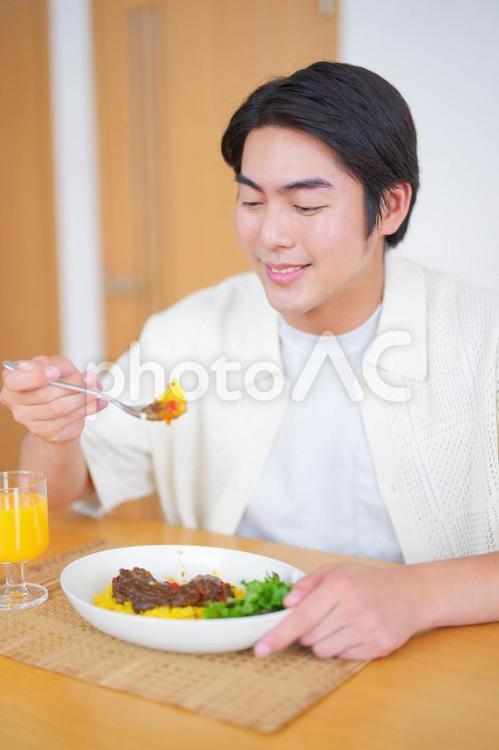 スプーンの料理を見つめる男性 男性,キーマカレー,食べるの写真素材