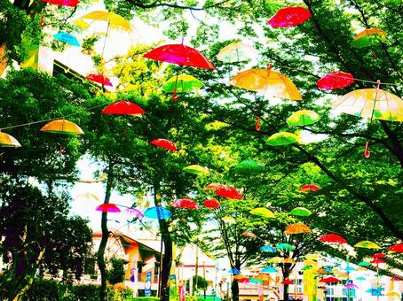 A green courtyard with colorful umbrellas fluttering about, JPG A green courtyard with colorful umbrellas fluttering about, JPG