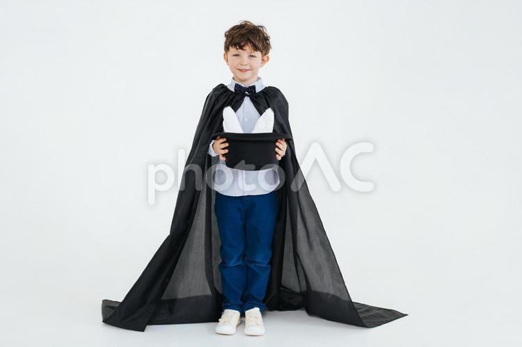 白い耳が見える黒い帽子を持つ笑顔の男の子 男の子,帽子,持つの写真素材