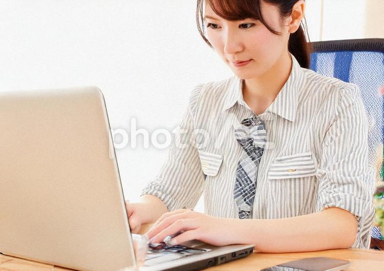 ノートパソコンに向かって仕事をするOL ol,ノートパソコン,仕事の写真素材