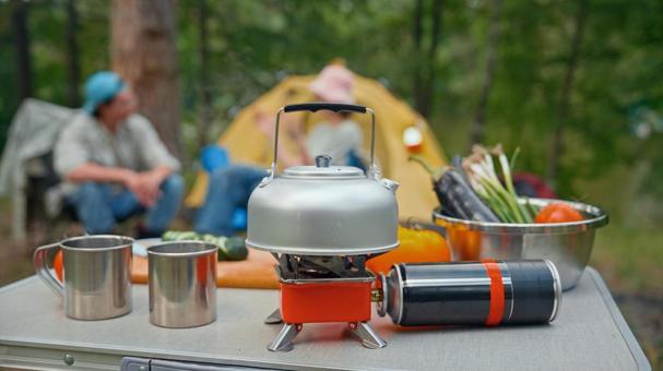 森の中の調理用キャンプ用品 ケトル,コンロ,ガス缶の写真素材