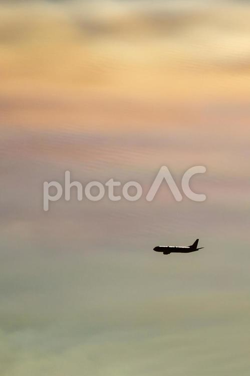 虹色の夕暮れ空を飛ぶ飛行機シルエット 飛行機,空,背景の写真素材