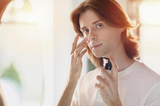 頬に乳液を塗る若い男性 男性,外国人,欧米人の写真素材