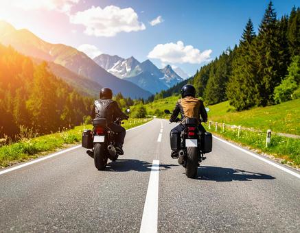 森と山に囲まれた直線道路を行くバイク 森と山に囲まれた直線道路を行くバイクの写真