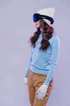 ゴーグルをかけたスキーの装いの女性 ゴーグルをかけたスキーの装いの女性の写真