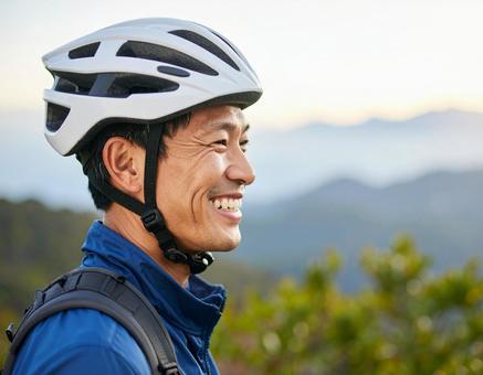 自転車用ヘルメットをかぶる男性 自転車用ヘルメットをかぶる男性の写真