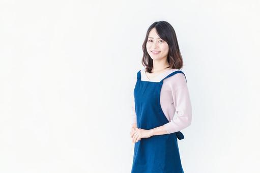 エプロンを着た笑顔の主婦 エプロンを着た笑顔の主婦 家事代行,サポート,ポジティブの写真素材