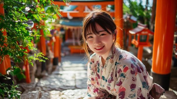 神社の境内にいる浴衣姿の若い女性 神社の境内にいる浴衣姿の若い女性の写真