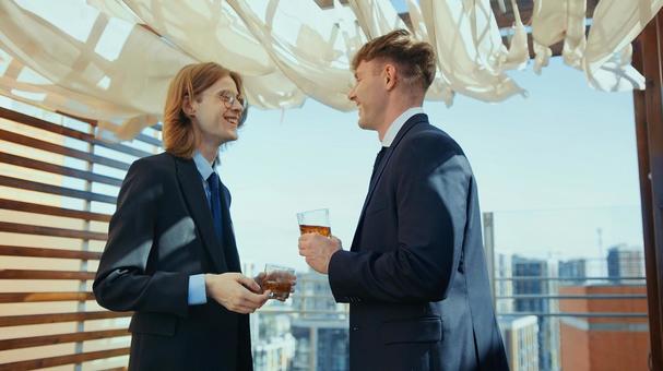 笑顔でグラスを持ち談笑する外国人男性 男性,外国人,笑顔の写真素材