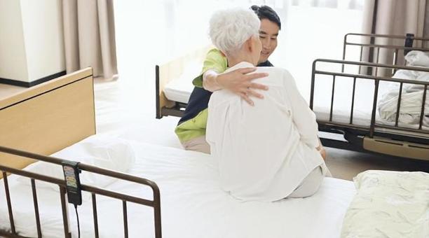 高齢者の体位変換を行うアジア人介護士 高齢者の体位変換を行うアジア人介護士 介護士,高齢者,体位変換の写真素材