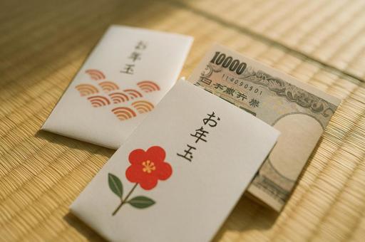 お年玉袋と一万円札の正月シーン お年玉袋と一万円札の正月シーンの写真