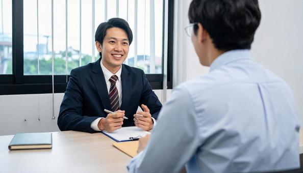 オフィスで面談する日本人ビジネスパーソン オフィスで面談する日本人ビジネスパーソンの写真