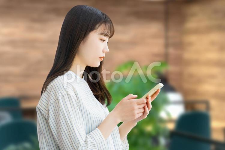 スマホを操作をする若いビジネスウーマン 女性,ビジネス,ビジネスウーマンの写真素材