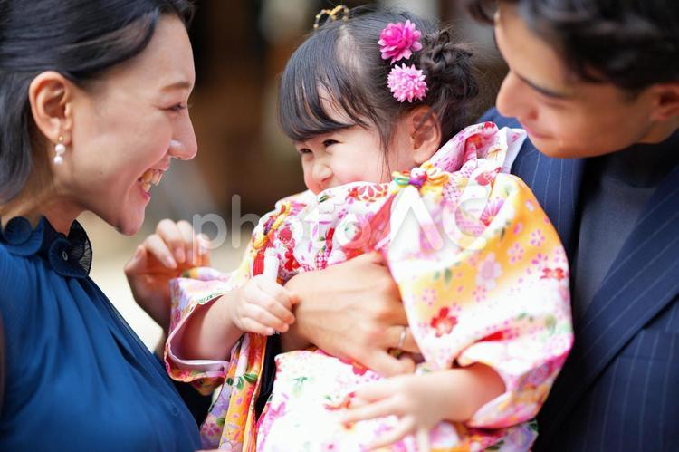家族に囲まれて嬉しそうに笑う女の子 七五三,お参り,七五三参りの写真素材