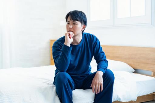 パジャマで考える男性 パジャマで考える男性の写真