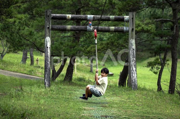 R＜素材＞公園のターザンロープで遊ぶ少年 子供,ターザンロープ,遊具の写真素材