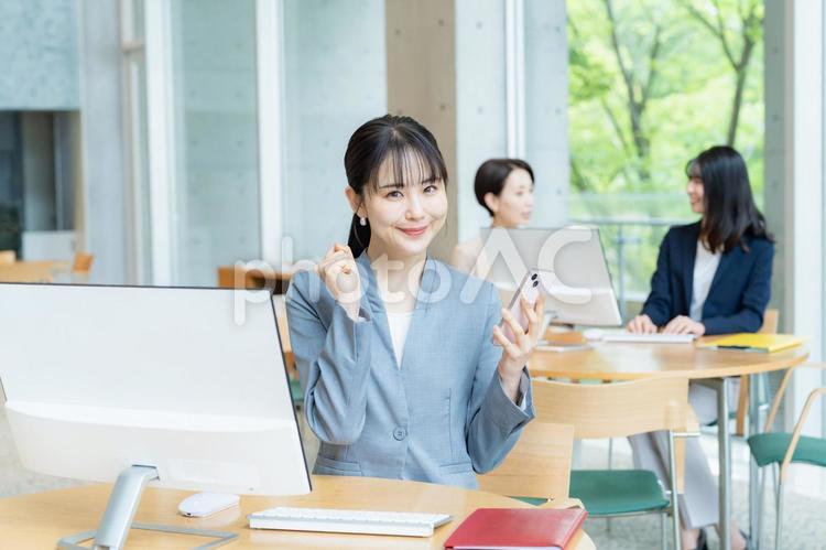 スマホを操作するビジネスウーマン スマホ,笑顔,ビジネスウーマンの写真素材