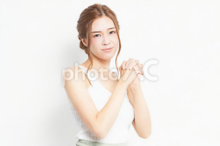 お願いのジェスチャーをする若い女性 女性,お願い,ポーズの写真素材