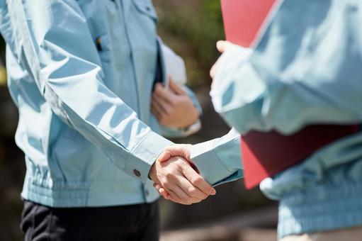 Construction worker shaking hands in front of the building, handshake, construction operator, alliance, JPG