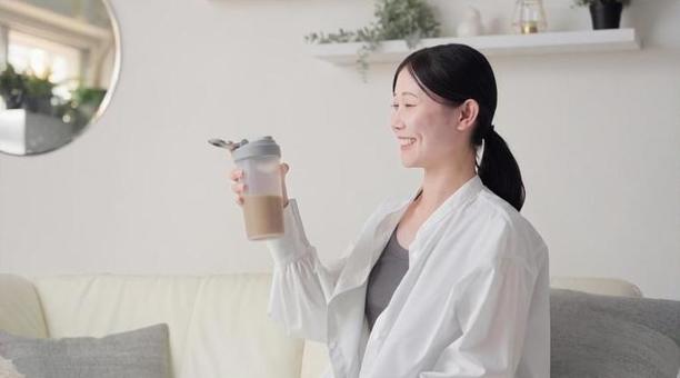 リビングでプロテインを見るアジア人女性 プロテイン,見る,女性の写真素材