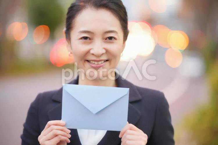 封筒を持っている女性 女性,水色,封筒の写真素材