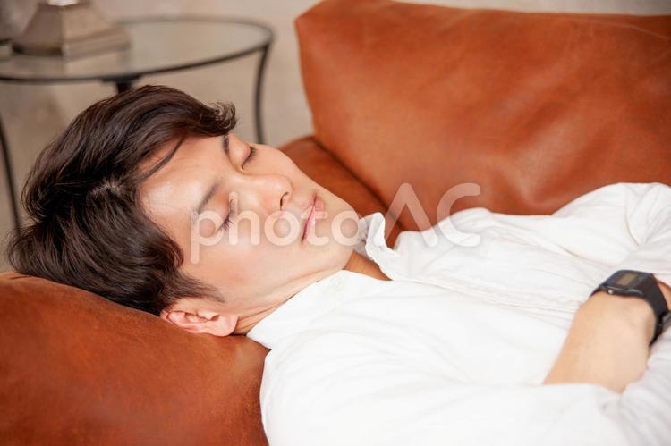 ソファで寝る男性 睡眠,爆睡,仮眠の写真素材