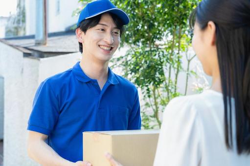 荷物を配達をする宅配業者 荷物を配達をする宅配業者の写真