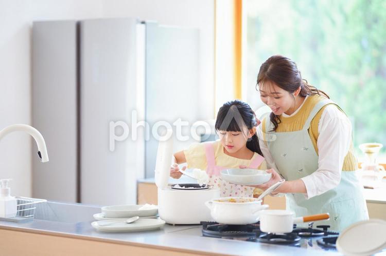 しゃもじでご飯を盛り付ける女の子 母,娘,炊飯器の写真素材