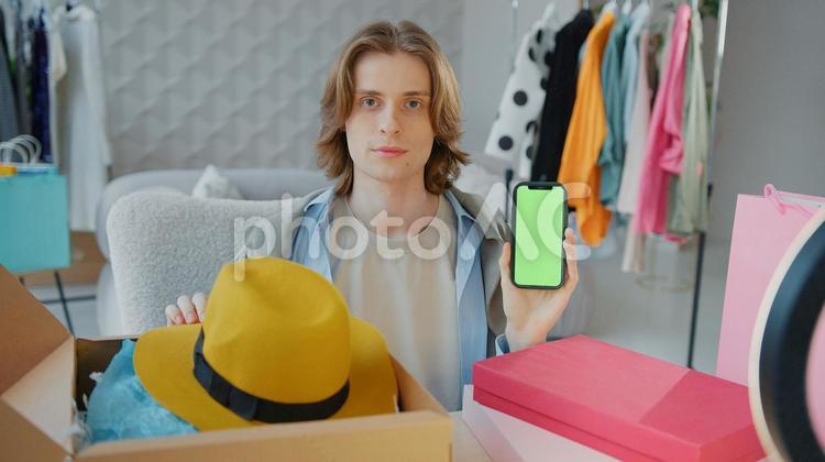 携帯を見せてカメラ目線の男性 男性,人物,携帯の写真素材
