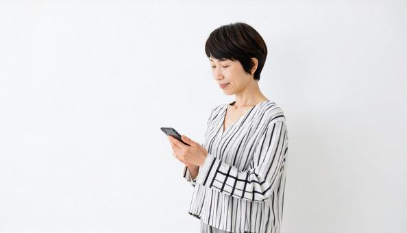 スマホを操作する女性 スマホを操作する女性の写真
