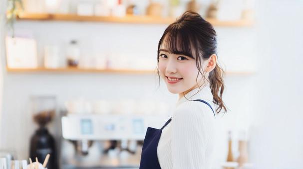 カフェで働く笑顔の女性スタッフ カフェで働く笑顔の女性スタッフの写真