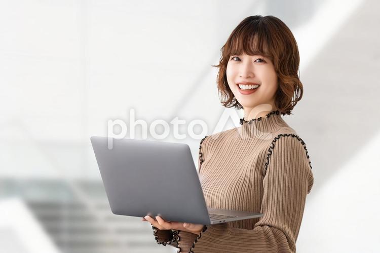 ノートパソコンを持つビジネスウーマン 女性,ビジネス,笑顔の写真素材