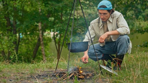 火の様子をうかがう男性 男性,外国人,鍋の写真素材