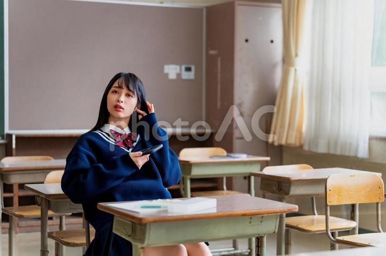 携帯を持ちながら会話をする女子高生 女子高校生,高校生,女子高生の写真素材
