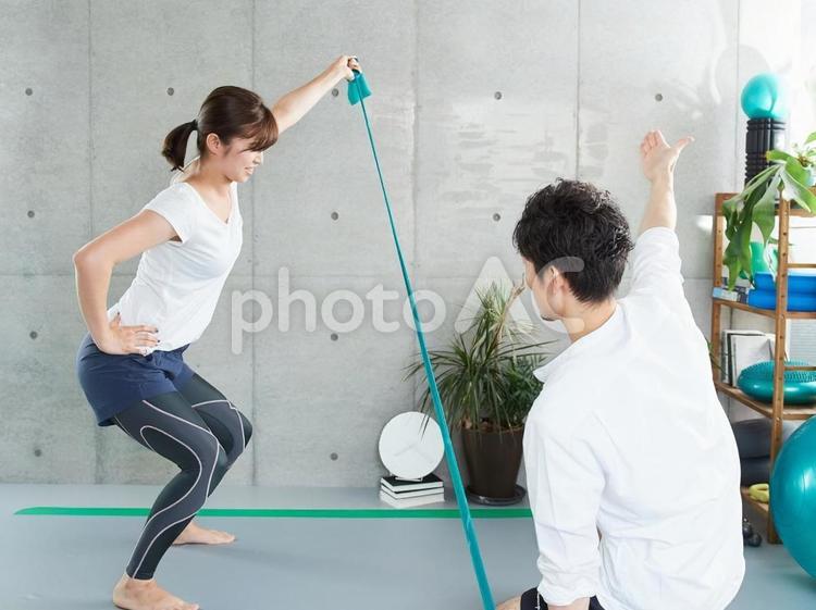 チューブトレーニングの指導を受ける女性 パーソナルトレーニング,指導,ジムの写真素材