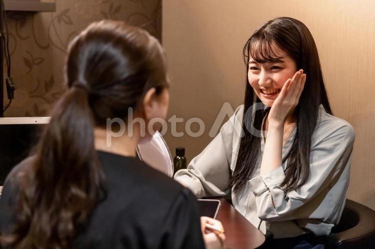 カウンセリングを受ける女性（鏡・ハリ） カウンセラー,ビューティーアドバイザー,肌診断の写真素材