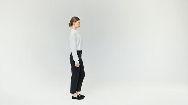 横向きで立つお団子ヘアの女性 横向きで立つお団子ヘアの女性の写真