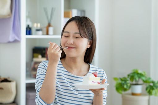 ケーキを食べる若い女性 ケーキを食べる若い女性 ケーキ,女性,スイーツの写真素材