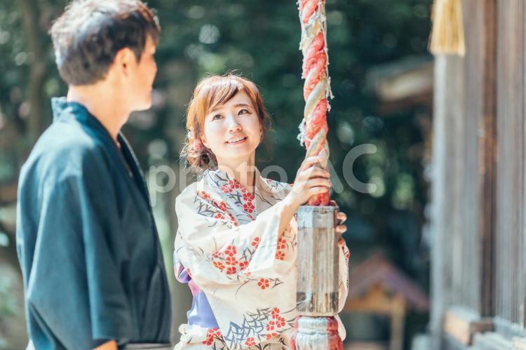 お参りして鈴を鳴らす浴衣姿の男女 神社,お参り,鈴の写真素材