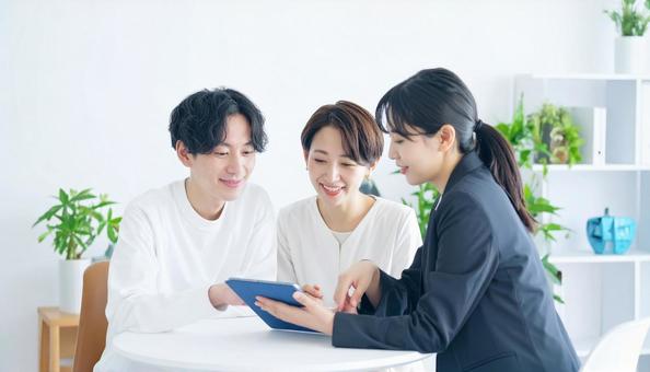 タブレットを使って説明する女性営業マン タブレットを使って説明する女性営業マンの写真