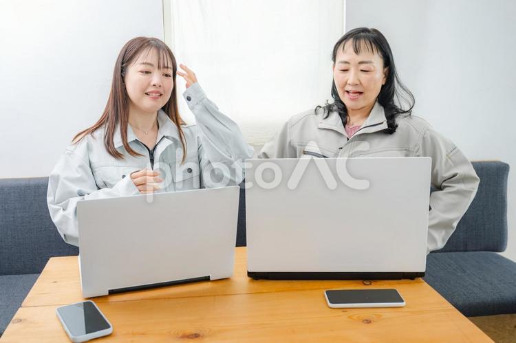 PCと二人の作業服女性 テレワーク,リモートワーク,サポート業務の写真素材