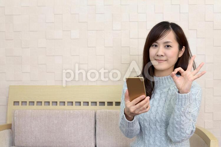 OKサインを出す笑顔の女性 女性,スマートフォン,女の写真素材