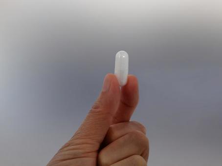薬を指でつまむ 薬,カプセル,カプセル錠の写真素材