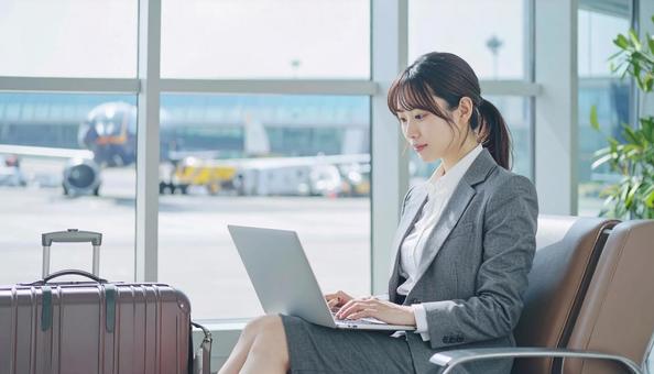 出張先の空港で仕事をするビジネスマン 出張先の空港で仕事をするビジネスマンの写真